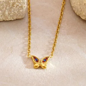 Dettaglio ravvicinato della collana a farfalla in oro 18k con zirconi rossi e blu