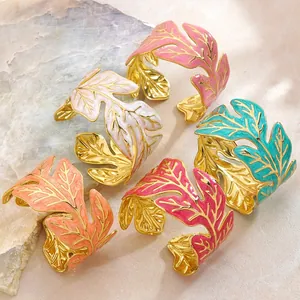 Dettaglio di bracciali a foglia in smalto colorato in acciaio inossidabile dorato con vene