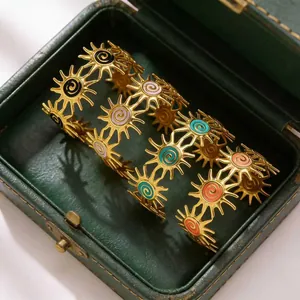 Macro detail of sunburst motif bangles with colorful enamel inlay in a jewelry box