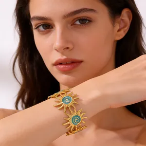 Detailed shot of golden sun-shaped bangle with blue enamel on female wrist