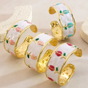 Bracciali rigidi dorati smaltati in stile boho con fiori su sfondo di pietra