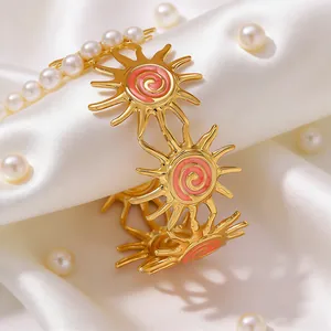 Retro stainless steel sun bangle with colorful enamel swirl on white silk fabric
