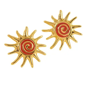 Elegant gold sunburst stud earrings with red enamel spiral center in a vintage style