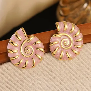 Macro detail of gold-plated conch earrings with pink marble enamel and retro shell design