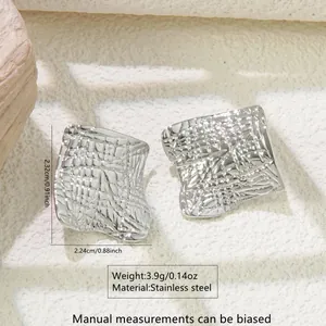 Detailed view of silver stainless steel square earrings with irregular hammered texture