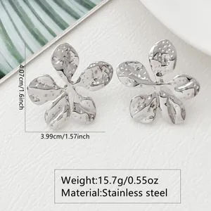Macro view of silver flower earrings with hammered texture and precise size measurements