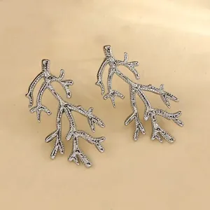 Detailed view of silver coral-shaped stud earrings with textured metallic finish