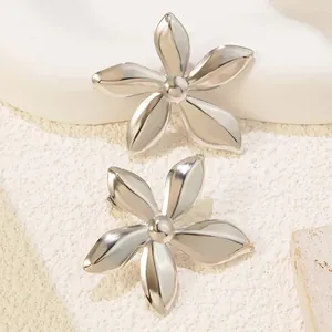 Detailed view of silver five-petal flower stud earrings with a polished mirror finish