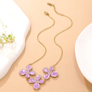Detailaufnahme der goldenen Edelstahlkette mit lila emaillierten Blumenanhängern