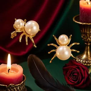 Gold spider pearl earrings on red silk background with candles for Halloween luxury style