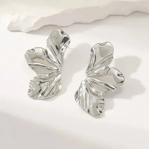 Macro shot of silver titanium steel floral earrings with polished ripple texture on stone
