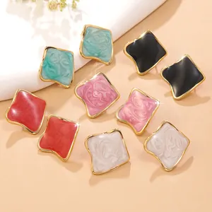 Vue détaillée de boucles d'oreilles émaillées carrées en cinq couleurs à bords dorés