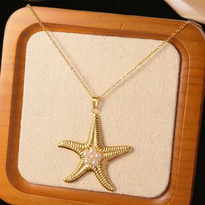 Détail macro du pendentif étoile de mer doré avec perles sur un plateau en bois