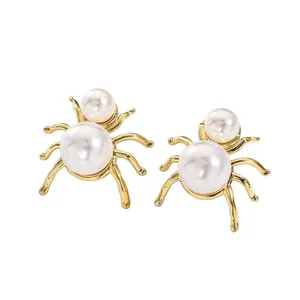 Elegant 18k gold-plated spider stud earrings featuring white pearls on a clean background