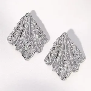 Macro shot of silver liquid metal geometric flower earrings with wrinkled texture surface