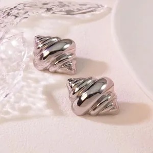 Detailed close-up of silver croissant dome earrings with polished mirror finish texture