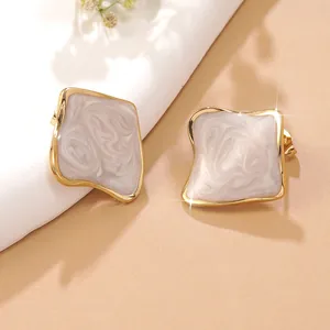 Boucles d'oreilles dorées géométriques avec émail marbré crème au design élégant