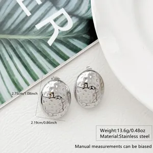 Detailed view of silver stainless steel oval earrings with hammered texture and dimensions