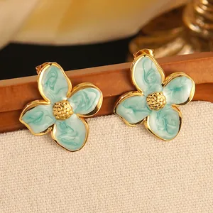 Dettaglio di orecchini a forma di frangipani in smalto azzurro e finitura dorata
