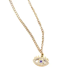 Gold Evil Eye pendant necklace with blue crystal and white enamel inlay on cross chain