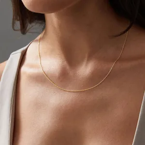 Close-up of minimalist 14K gold-plated stainless steel cable chain on a woman neck