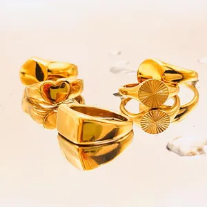 Ensemble de bagues dorées 18K avec motifs cœur sur surface d'eau avec reflets