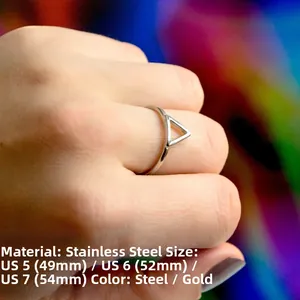 Anello geometrico minimalista in acciaio inossidabile indossato con sfondo di luci bokeh sfocate