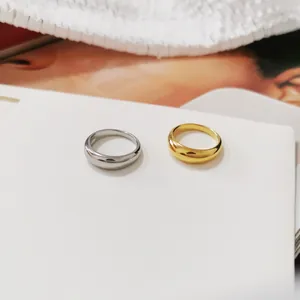 Minimalistische dicke Wellenringe in poliertem Gold und Silber auf einem Magazin
