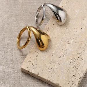 Anelli aperti a cuore astratto in oro 18k e argento su supporto in pietra beige