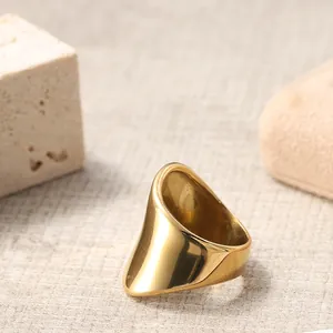 Dettaglio macro di un anello largo dorato lucido con design geometrico asimmetrico