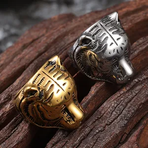 Retro tiger head stainless steel rings in gold and silver finish on dark wood texture