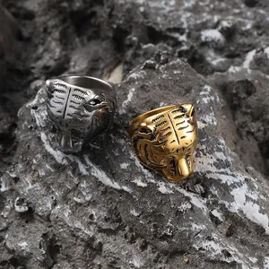 Detailed macro shot of gold and silver tiger head rings on a rugged stone background