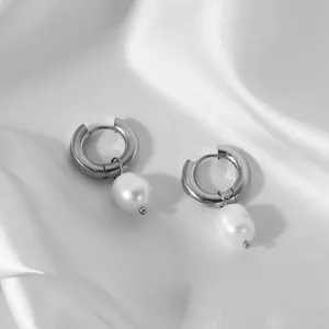 Gros plan de boucles d'oreilles anneaux en argent avec perle d'eau douce sur soie blanche
