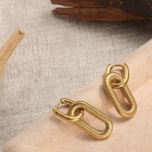 Makroaufnahme goldener Ohrringe mit gedrehtem Gewindemuster und Retro-Metall-Finish