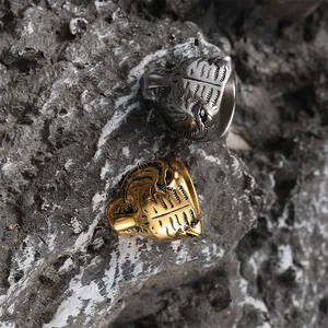 Rugged men's tiger head rings in gold and silver finish on natural stone background