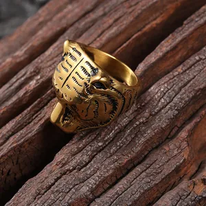 Detailed macro shot of a golden tiger head ring with black engraved stripes on wood