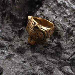 Macro shot of detailed tiger head ring with vintage golden finish on dark rock background