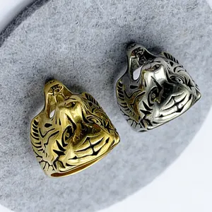 Detailed close-up of tiger head rings in gold and silver finishes with vintage engravings