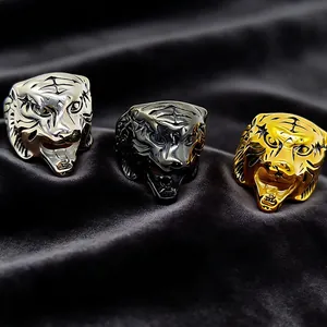 Detailed tiger head rings shown in gold, silver, and black finishes on dark velvet