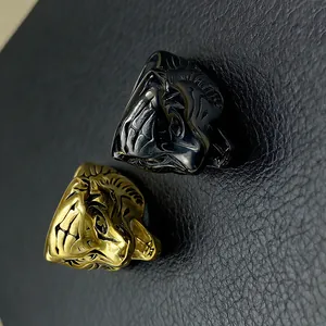 Macro detail of gold and black tiger head rings on a textured black leather background