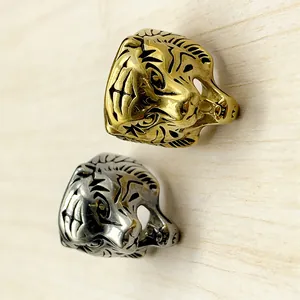 Close-up of hip-hop tiger head rings in gold and silver finish with detailed engraving