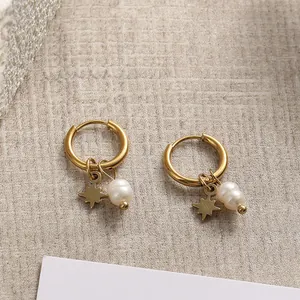 Detailaufnahme von goldenen Edelstahl-Creolen mit Sternanhängern und weißen Perlen