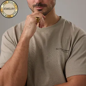 Detail of men's vintage gold stainless steel signet ring with geometric star on index finger