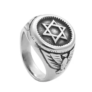 Vintage stainless steel ring with hexagram symbol and eagle wing relief on white background