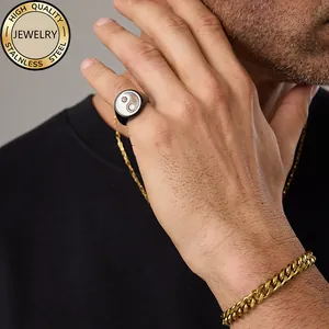 Detail shot of Yin Yang signet ring worn with gold Cuban chain and necklace