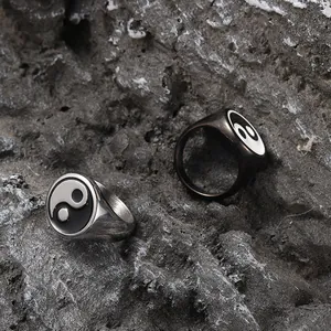 Vintage stainless steel Tai Chi Yin Yang rings in silver and black on grey rock