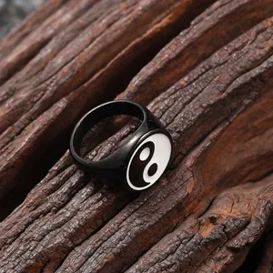 Macro shot of vintage stainless steel Tai Chi Yin Yang ring on a rustic wood background