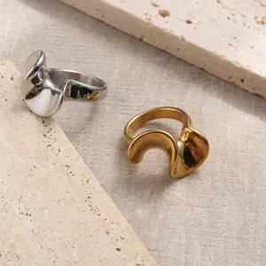 Minimalist 18K gold and silver plated stainless steel irregular wavy rings on stone base