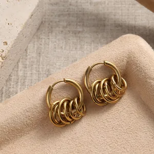 Close-up of gold titanium steel hoop earrings featuring five small dangling rings on a tray