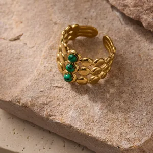 Vintage 18k gold plated stainless steel ring with three malachite green stones on a rock